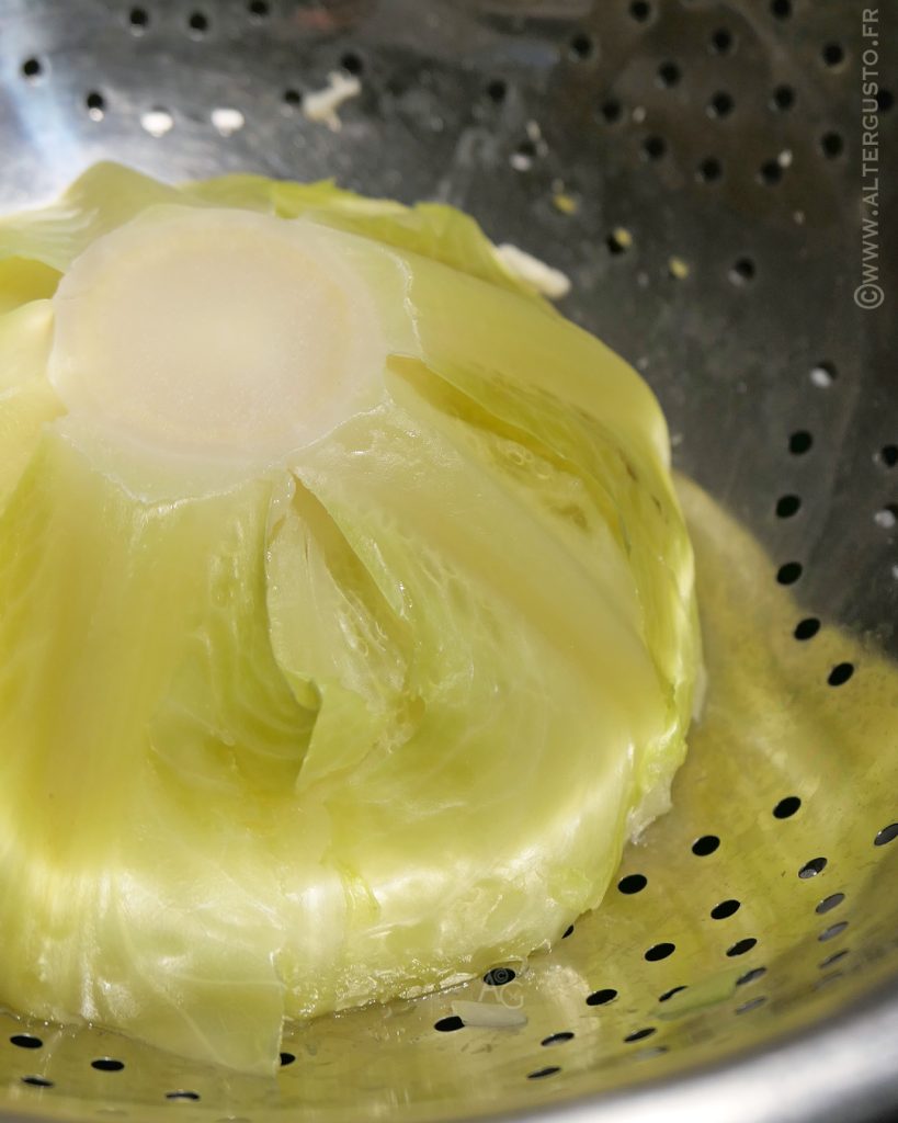 Demi-chou blanc égouttant côté coupé vers le bas dans une passoire